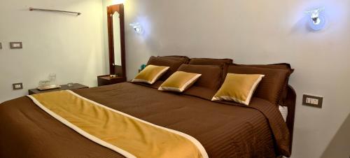 a bedroom with a large bed with two pillows at Ponmurugan Residency in Kodaikānāl