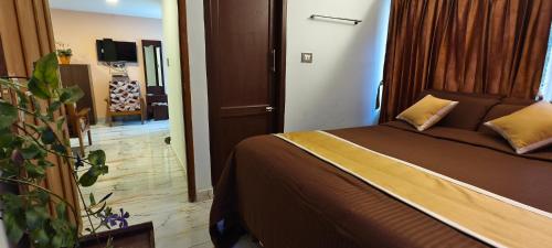 a bedroom with a bed and a door to a room at Ponmurugan Residency in Kodaikānāl