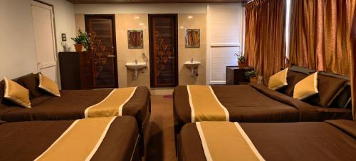 a hotel room with two beds and a sink at Ponmurugan Residency in Kodaikānāl