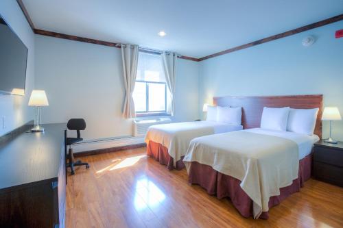 a hotel room with two beds and a window at LIC Hotel in Queens