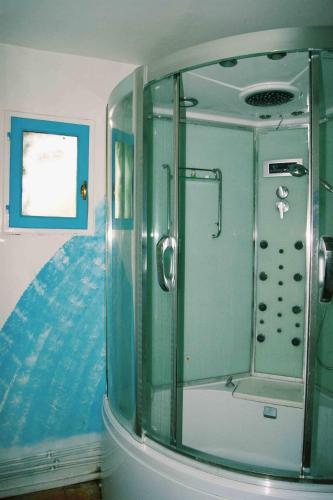 une salle de bain avec une douche avec une porte vitrée dans l'établissement Le clos des vignes, à Montlouis-sur-Loire