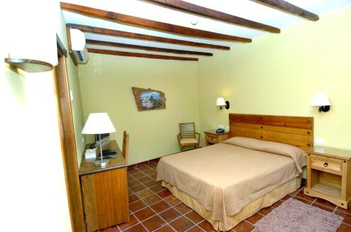 a bedroom with a bed and a table and a chair at HOTEL FONDA de La TEA in Tejeda
