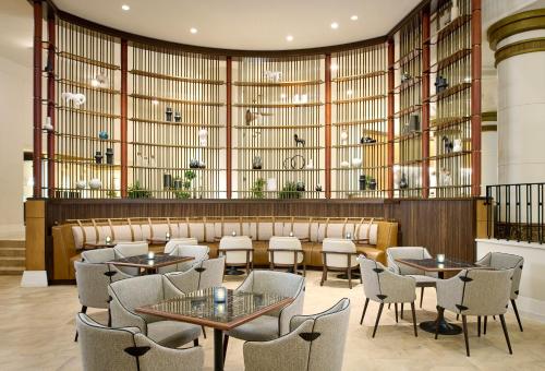 a restaurant with tables and chairs and a large window at Salamander Washington DC in Washington, D.C.