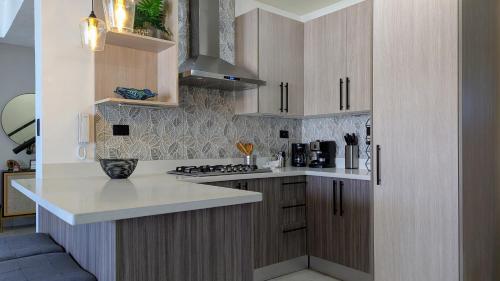 a kitchen with wooden cabinets and white counter tops at Mountain View Penthouse Condo in Muñoz