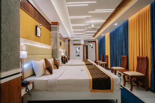 a hotel room with a bed and chairs at Excellency Airport Hotel in Angamali