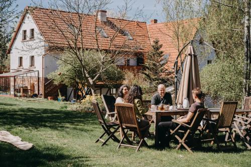 a group of people sitting at a table in a yard at GAJRAJ in Wünschelburg