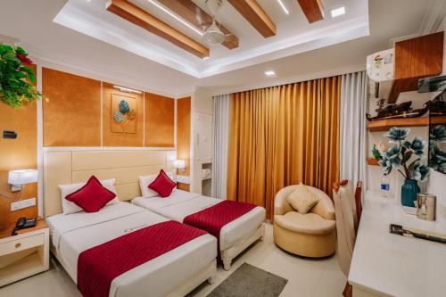 a hotel room with a bed and a chair at Excellency Airport Hotel in Angamali