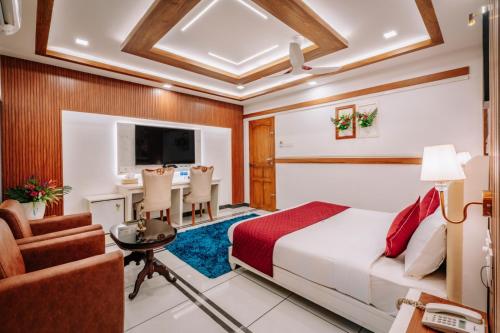 a hotel room with a bed and a table and chairs at Excellency Airport Hotel in Angamali