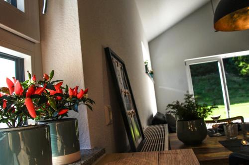 a room with two vases with flowers on a table at Ferienhaus AlbSommer - FehlaTal in Burladingen