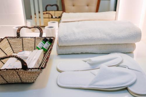 a bathroom with towels and flip flops on a table at Excellency Airport Hotel in Angamali