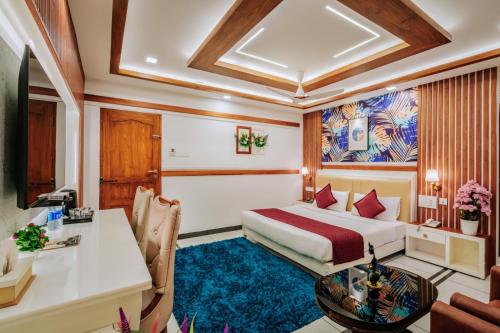 a hotel room with a bed and a desk at Excellency Airport Hotel in Angamali