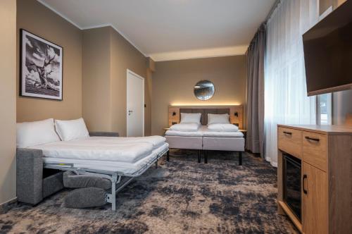 a hotel room with two beds and a tv at Thon Partner Notodden in Notodden