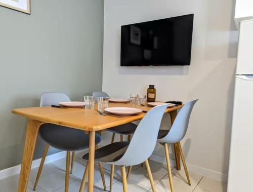 a dining room with a wooden table and chairs at L'apostrophe - Duplex et terrasse in Douai