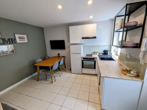 a kitchen with a table and a counter top at L'apostrophe - Duplex et terrasse in Douai