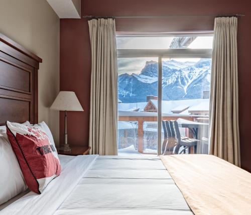 a bedroom with a bed and a view of a mountain at Sun Drenched Escape in Canmore