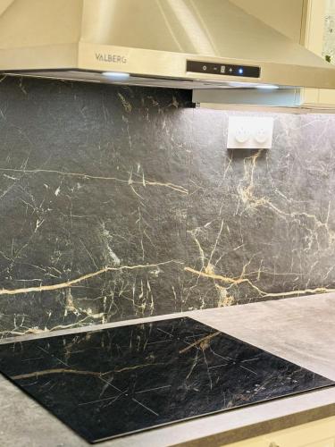 - une cuisine avec un comptoir en marbre noir dans l'établissement Grand Paris Cozy Stay Private Studios and Apartment Quick Access to Paris, à Vitry-sur-Seine