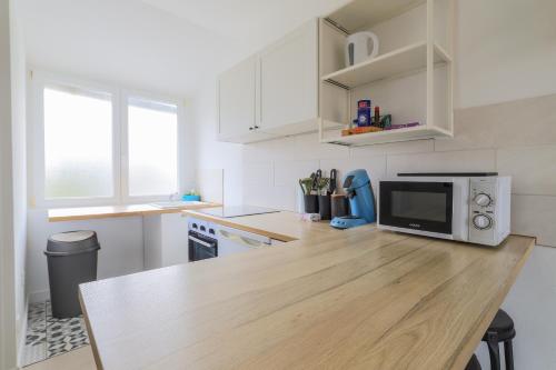 - une cuisine avec un comptoir en bois et un four micro-ondes dans l'établissement Casetta - Arrière Gare, à Arras