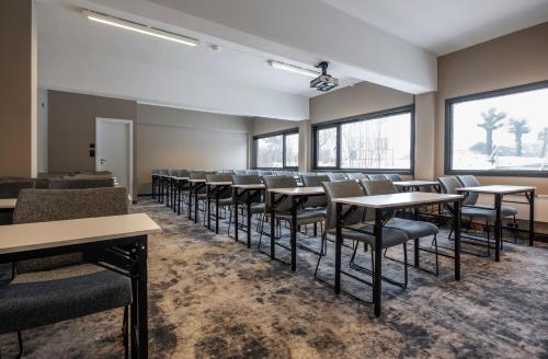 a row of tables and chairs in a room with windows at Thon Partner Notodden in Notodden