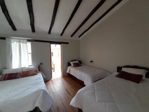 a bedroom with two beds and a window at Pisonaywasi - Hospedaje familiar in Urubamba