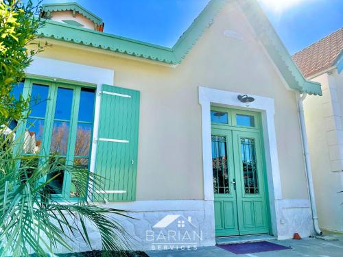 une maison avec une porte verte devant elle dans l'établissement Perle Fourasine - Vue Mer - 2 minutes de la plage, à Fouras