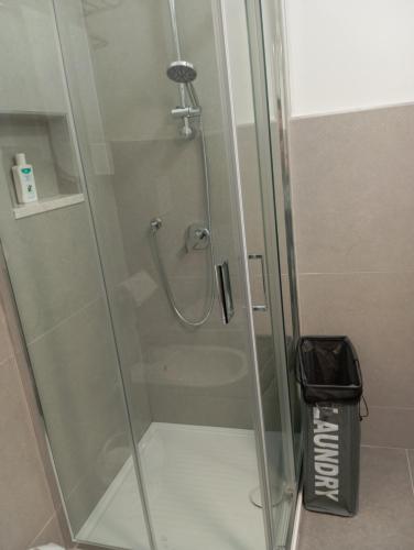 a shower with a glass door with a trash can at La Piccola Gemma in Serramanna