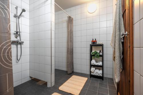 a bathroom with a shower with white tiles at Thon Partner Notodden in Notodden