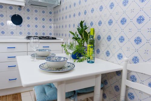 a white kitchen with blue and white tiles at Hillside Studio with Sea View & Fibre Internet in Albufeira