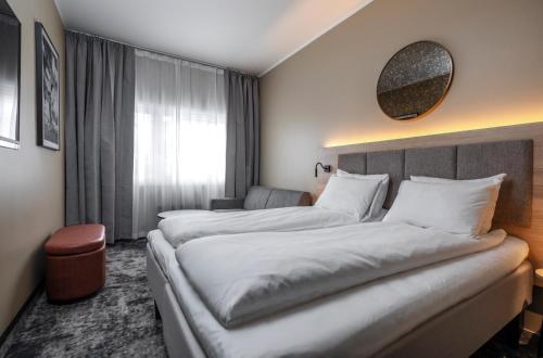a hotel room with two beds and a mirror at Thon Partner Notodden in Notodden