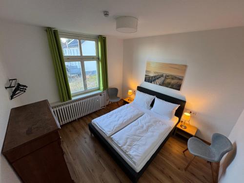 ヴァルタースハウゼンにあるPension Villa am Burgbergのベッドと椅子のある寝室