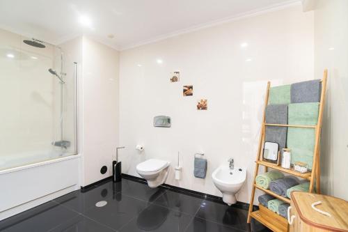 a white bathroom with a toilet and a sink at Natural Living Vacations in Furnas