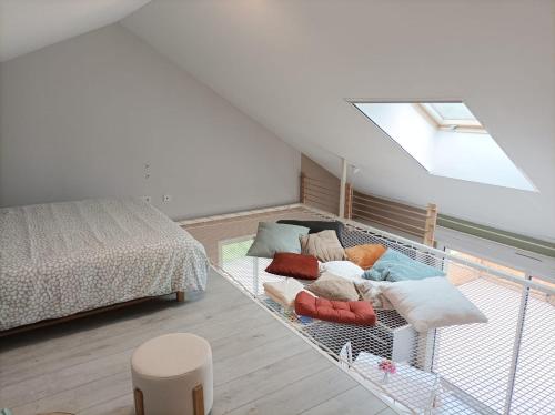 a bedroom with a bed and a couch with pillows at " L'instant Nid d'où " , Spa et Luxe Intime in Baneuil