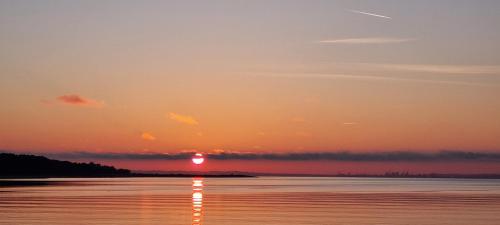 a sunset over a body of water at Rødegaard Mols in Knebel
