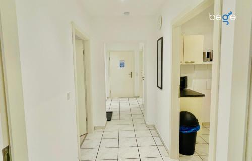 a hallway leading to a kitchen with a white tile floor at BEGE APARTMENTS Rent & Repeat in Mettmann