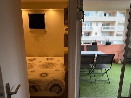 une chambre avec un lit, une table et un balcon dans l'établissement Dernier étage avec garage, piscines et tennis, à Cagnes-sur-Mer