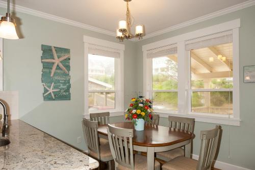 a dining room with a table and chairs and windows at A Bit of R n R in Lincoln City