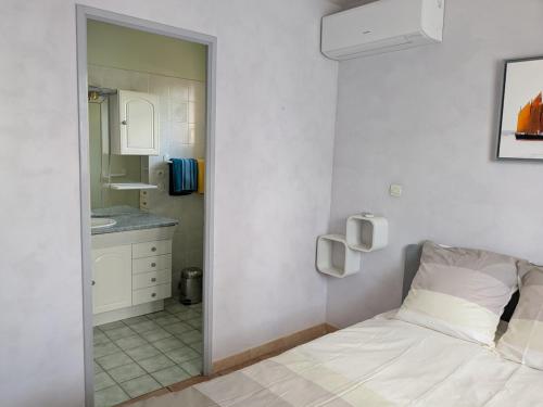 Un dormitorio con una cama, un lavabo y un espejo. en Entre plage et vignobles Maison trois chambres, en Saint-Cyr-sur-Mer