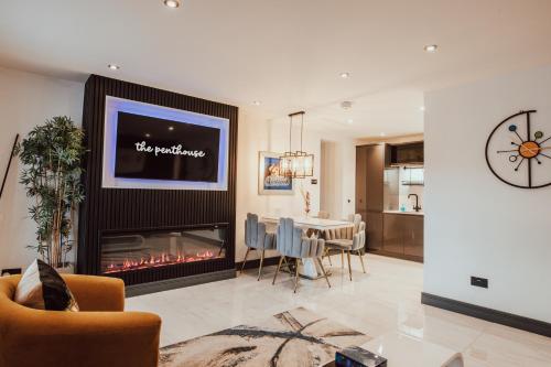 a living room with a fireplace and a dining room at The Penthouse Luxury Central Apartment in Glossop