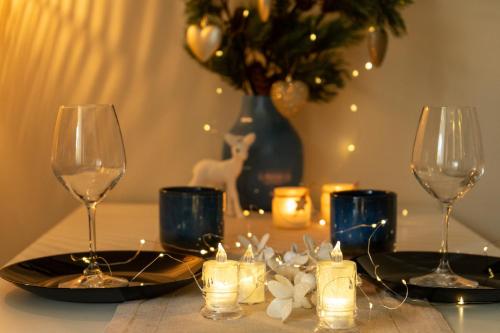 Una mesa con dos copas de vino y un jarrón con velas. en Home-Like Studio Walking Distance to the Old Town l Washing Machine l Bus Station Nearby, en Novi Sad