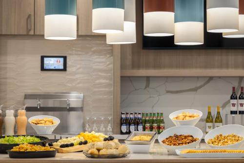a kitchen with many plates of food on a counter at Homewood Suites By Hilton Thornton Denver in Thornton
