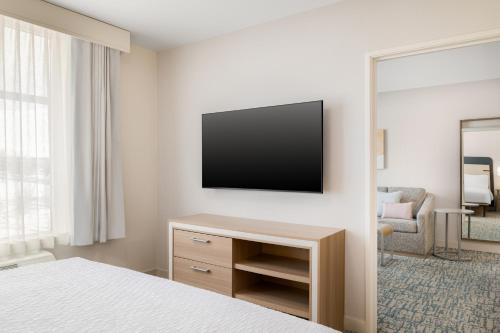 a hotel room with a television on a wall at Homewood Suites By Hilton Thornton Denver in Thornton