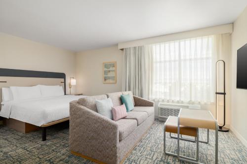 a hotel room with a bed and a couch at Homewood Suites By Hilton Thornton Denver in Thornton