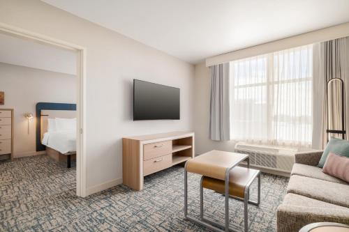 a hotel room with a couch and a bed at Homewood Suites By Hilton Thornton Denver in Thornton