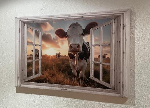 a picture of a cow looking out of a window at Zum Fröhlich in Großweil