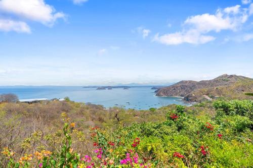 a view of a body of water with flowers at Villa Isla Azul in Ocotal