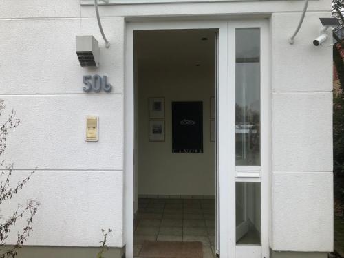 an entrance to a white building with a sliding glass door at PentArtHouse in Burscheid
