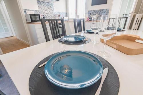 une table avec une assiette bleue et des verres à vin dans l'établissement bulles, à Épernay