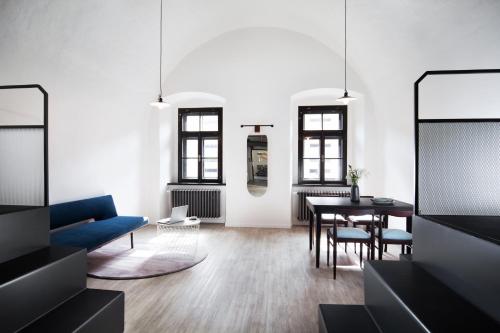 a living room with a blue couch and a table at Long Story Short Hostel & Café in Olomouc