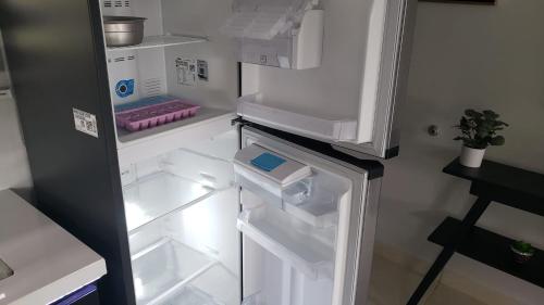 an empty refrigerator with its door open in a kitchen at Tropical Noir at Family Lodge in Jabillos