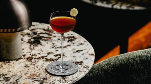 a glass of wine sitting on top of a table at InterContinental Singapore Robertson Quay by IHG in Singapore