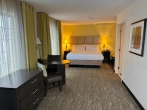a hotel room with a bed and a desk at Candlewood Suites Eugene Springfield by IHG in Eugene